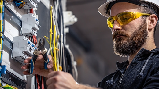 An electrician working on a circuit breaker.